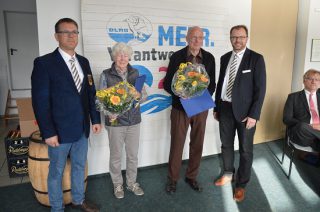 (Foto: DLRG Lübeck): Auszeichnung für langjährige Mitglieder (v.l.) Henning Otto (Geschäftsführer und stellv. Vorsitzender), Anke-Marie Lohrisch (65 Jahre Mitgliedschaft), Peter Saldigkt (60 Jahre Mitgliedschaft und Thomas Becker (Vorsitzender) 